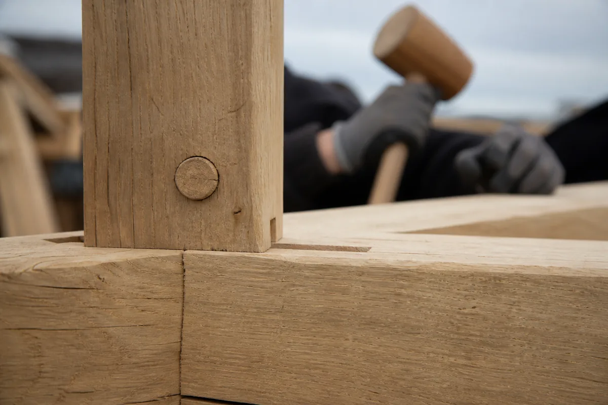 Ferme de charpente traditionnelle en chêne clair sous des combles à nu, assemblage par tenon et cheville